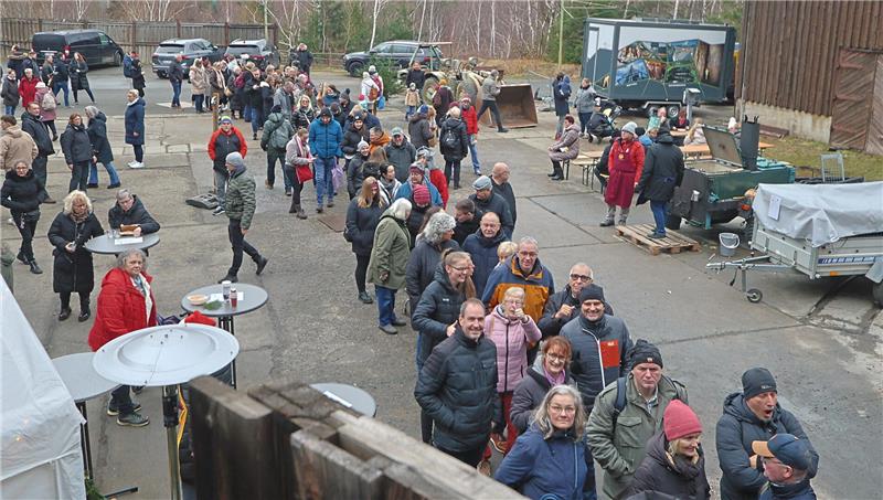 Mit gut 10.000 Besuchern ist die Belastungsgrenze erreicht Viele Menschen stehen auf einem Außengelände in einer langen Schlange.