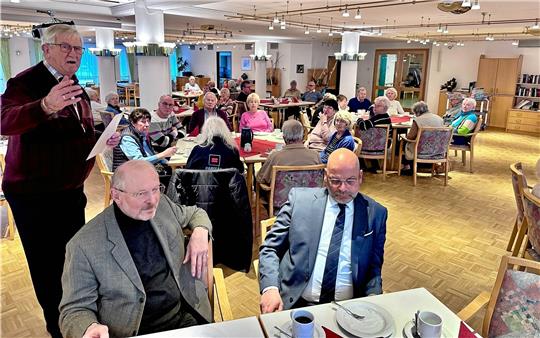 Vorsitzender Günter Rauer (stehend) begrüßt die Teilnehmer der adventlichen Feier, darunter auch Eugen Griesmayr (l.) von der katholischen und Propst Jens Höfel (r.) von der evangelischen Kirche. Foto: Schlegel