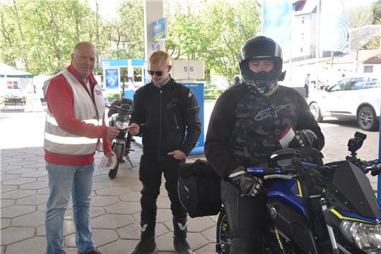 Vorsitzender Michael Krause (links) versorgt die beiden Yamaha-Fahrer Fabian Prevener und Matthias Stucken mit Flyern.  Foto: Breutel