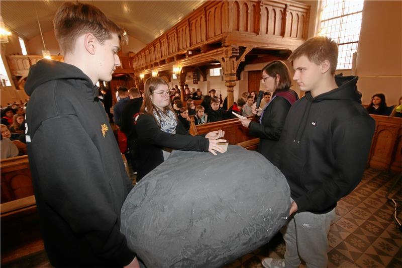 Geständnisse der Schladener Werla-Schüler auf dem Schuldstein Während Pfarrerin Sonja Achak Schuldeingeständnisse der Kinder und Jugendlichen vorliest, bekleben Werla-Schüler am Buß- und Bettag den im Kunstunterricht hergestellten Schuldstein mit den dazugehörigen Zetteln. Foto: Gereke