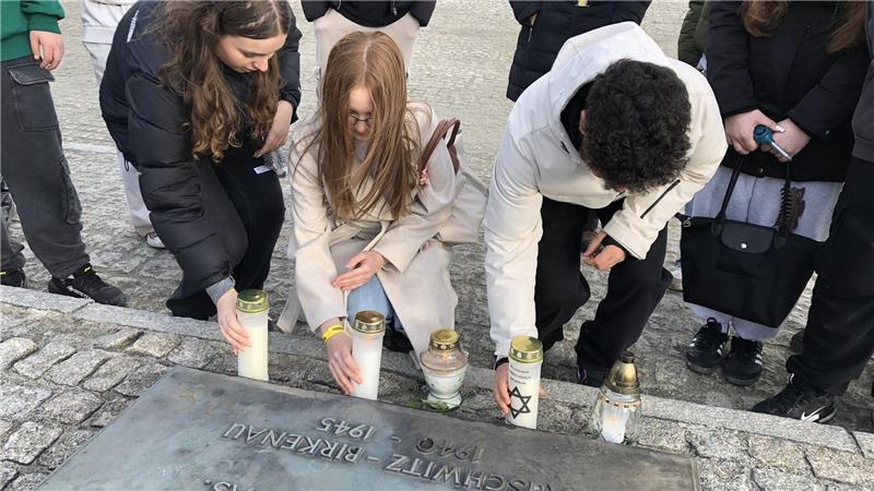 Schüler der Okeraner Adolf-Grimme-Schule fahren nach Auschwitz Während der Rede am Mahnmal entzünden Leonie Machner, Izabela Iwanowska und Ayamuddin Stanikzai (v. l.) selbst gestaltete Kerzen zum Gedenken an die ermordeten Goslarer.