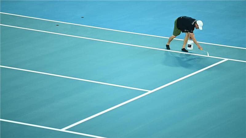 Während der Vorbereitungen für die Australian Open 2026 werden die Linien auf das Spielfeld aufgemalt.
