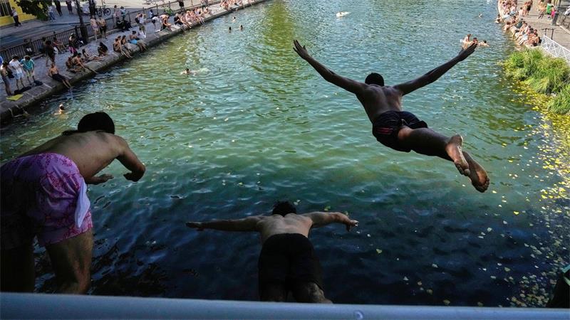Während einer Hitzewelle springen Menschen in Paris von einer Brücke in den Canal Saint-Martin.