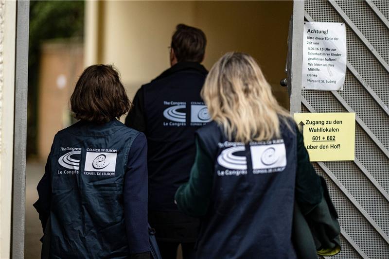 Wahlbeobachter des Europäischen Rates betreten ein Berliner Wahllokal.