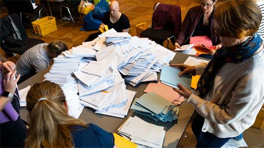 Wahlhelfer sortieren die Stimmzettel für die Auszählung der Briefwahl im Neuen Rathaus. 