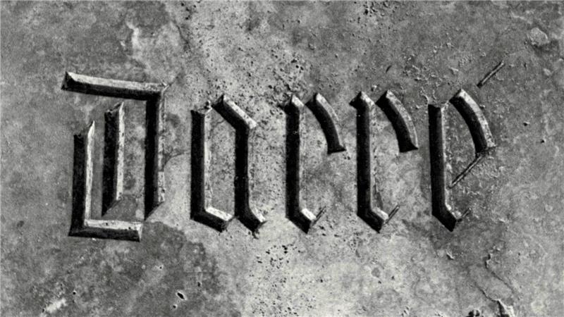 Das Wort 'darre' in gotischer Schrift auf einer steinernen Oberfläche.