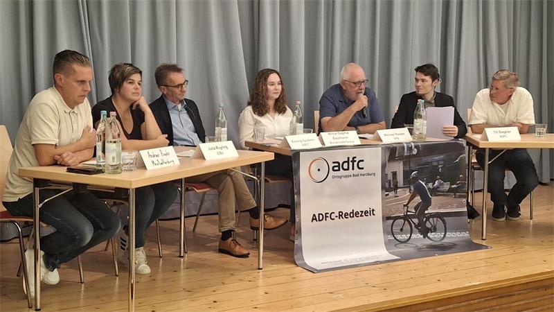 Eine Gruppe von Menschen sitzt auf einem Podium und diskutiert.
