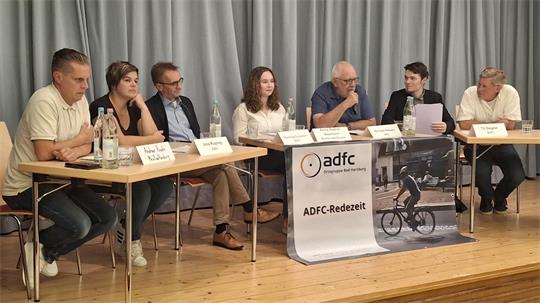 Eine Gruppe von Menschen sitzt auf einem Podium und diskutiert.