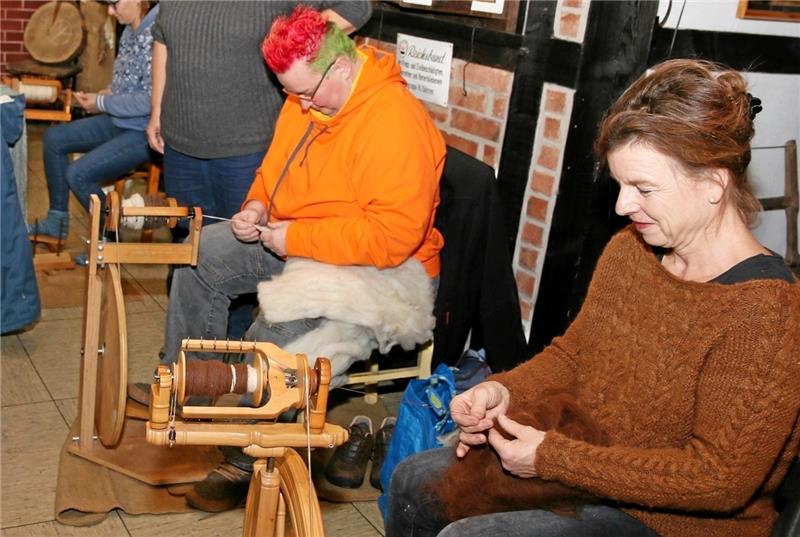 Uraltes Handwerk lebt im Museum auf „Was leicht aussieht, braucht viel Geschick. Der Fuß treibt das Spinnrad an und die Hände ziehen die Wolle zum Faden“, erklärt Dozentin Sandra Köhne (re.). Foto: Leifeld
