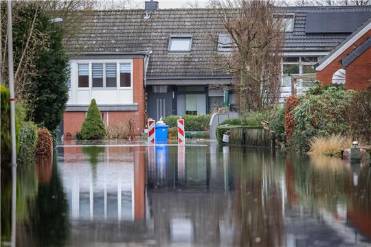 Wasser steht in einer evakuierten Wohnstraße nahe der Wörpe in Lilienthal.