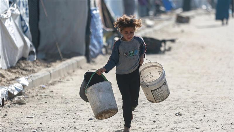 Wasser wird zum Luxus: Kind rennt mit leeren Eimern zu einer Wasserstelle in Gaza