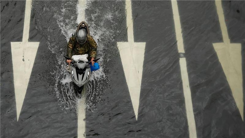 Wasserstraße: Ein Motorradfahrer fährt auf einer überfluteten Straße, nachdem Tropensturm Wipha über Manila auf den Philippinen gezogen ist. 