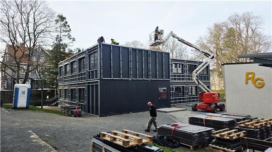 Mit einer Hebebühne werden Einzelteile der Container abgebaut. 