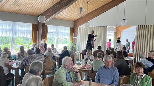 Wegen der vielen Regenschauer am Nachmittag sitzen die Besucher des Sommerfestes der Trinitatis-Kirchengemeinde zur Kaffeetafel im Gemeindehaus.