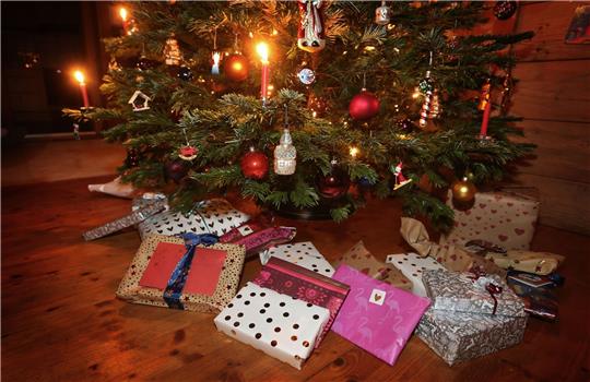 Weihnachtsgeschenke unter einem geschmückten Weihnachtsbaum.