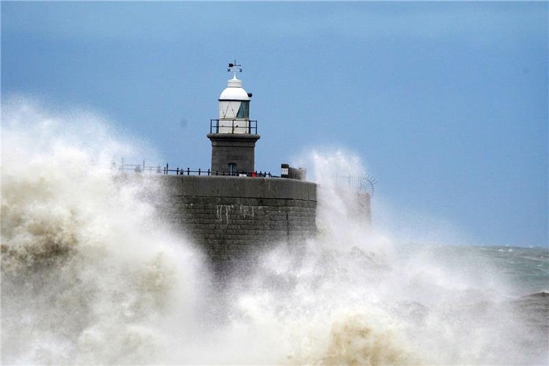 Orkantief trifft Westeuropa: Sieben Tote Wellen schlagen vor dem Leuchtturm an die Hafenmauer in Folkstone.