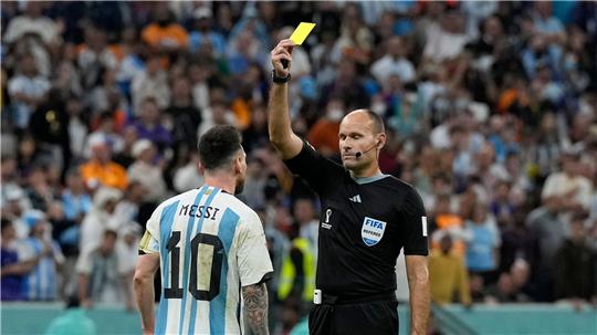 Weniger Gefahr für eine Gelbsperre: Hier wird Argentiniens Lionel Messi (l) bei der WM 2022 von Schiedsrichter Antonio Mateu Lahoz verwarnt. (Archivbild)