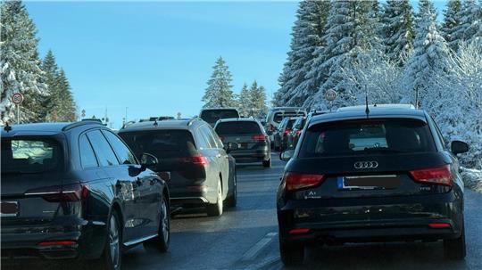 Auf der Straße stehen viele Autos im Stau. 