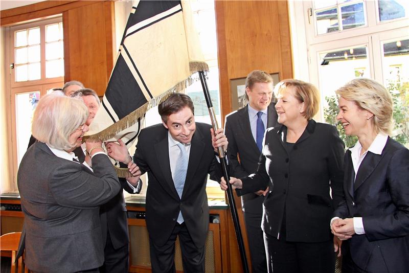 Wer schaut denn da unter der der historischen Fahne von 1950 hervor? Niedersachsens Ministerpräsident David McAllister macht den Spaß am 23. Oktober 2010 im Konrad-Adenauer-Zimmer des „Achtermanns“ mit. Kanzlerin Angela Merkel packt ebenfalls mit zu. Rechts freut sich Arbeitsministerin Ursula von der Leyen, links Goslars Bürgermeisterin Gudrun Pfeiffer.  Archivfoto: Kusian-Müller