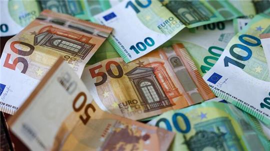 Mehrere 50- und 100-Euro-Banknoten liegen locker übereinander verteilt