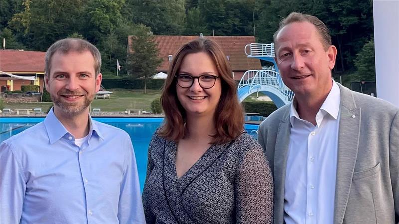 Drei Personen vor Wahlwerbeschildern 