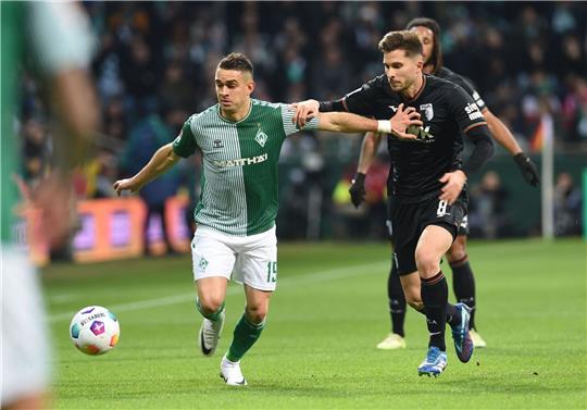Werders Rafael Borre (l) kämpft gegen Augsburgs Elvis Rexhbecaj um den Ball.