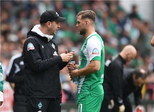 Werders Trainer Ole Werner spricht bei einer Trinkpause mit Niclas Füllkrug (r).