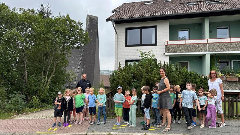 Polizist erklärt Erstklässlern, wie sie die Straße queren sollen Wie komme ich sicher zur Schule? Der Polizeibeamte Thomas Pauls, Lehrerin Nicole Günther und die pädagogische Fachkraft Nicole Pauls (rechts) erklären den neuen Erstklässlern, wie sie richtig über die Straße gehen.