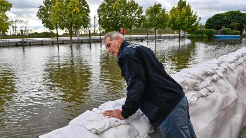 Oder-Region in Alarmstimmung - Helfer im Dauereinsatz Wie schlimm wird das Hochwasser? Frank Balzer (SPD), der Bürgermeister von Eisenhüttenstadt, blickt über einen Wall aus Sandsäcken im Stadtteil Fürstenberg, wo Straßen überflutet wurden.