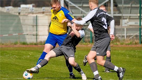 Wiedelahs Lennart Gadesmann (l.) und Gil-Pascal Brandt vom VfR Langelsheim rangeln um den Ball. Luis Diedrichs (r.) beobachtet die Szene.