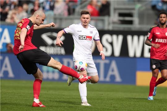 Wiesbadens Aleksandar Vukotic (l) und Osnabrücks Erik Engelhardt (r) kämpfen um den Ball.