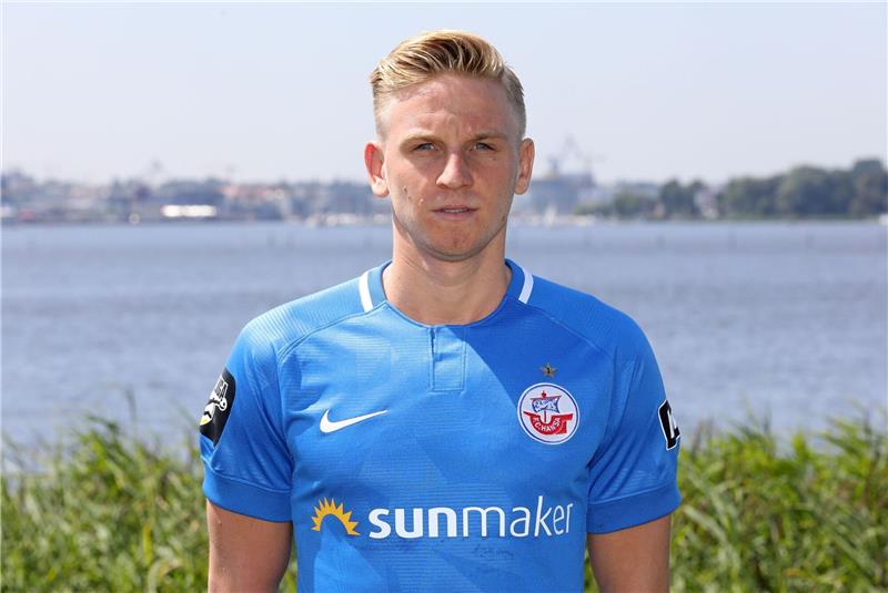 Willi Evseev steht beim offiziellen Fototermin beim Fußball-Drittligisten FC Hansa Rostock vor der Kamera.
