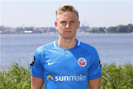 Willi Evseev steht beim offiziellen Fototermin beim Fußball-Drittligisten FC Hansa Rostock vor der Kamera.