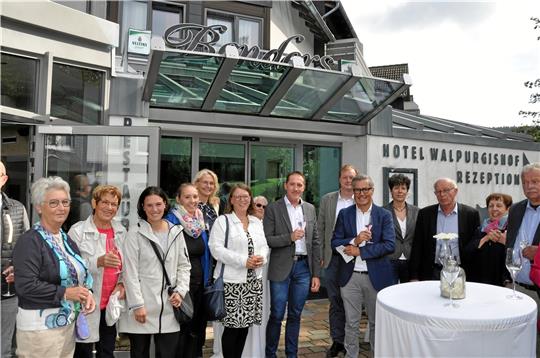 Willkommen im Hahnenkleer Kreis: Nils Backhaus (4. v. re.) ist neuer Geschäftsführer, Jan Roterberg (6. v. re.) schon seit Mai neuer Direktor im Hotel „Walpurgishof“. Der markante Restaurant-Schriftzug „Benders“ soll bald weichen, das Konzept nach dem Verkauf durch Vorbesitzer Axel Bender (noch) stärker am Walpurgis-Motiv ausgerichtet werden. Foto: Heine