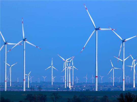 Windräder drehen sich nach Sonnenuntergang in einem Windpark. Foto: Jens Büttner/dpa-Zentralbild/dpa