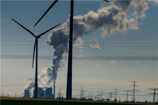 Windräder im Energiepark Bad Lauchstädt, eine Stromtrasse und qualmende Schornsteine in einem Industriegebiet.