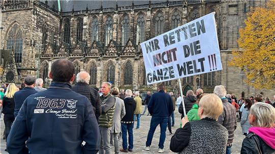 "Wir retten nicht die ganze Welt" steht auf dem Schild, das Menschen bei einer Demonstration tragen.