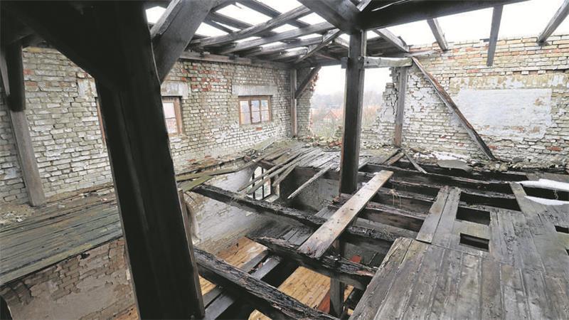 Verfallendes Gebäude, eine Hausecke ist abgebrolchen, durch den Boden fällt der Blick nach unten.