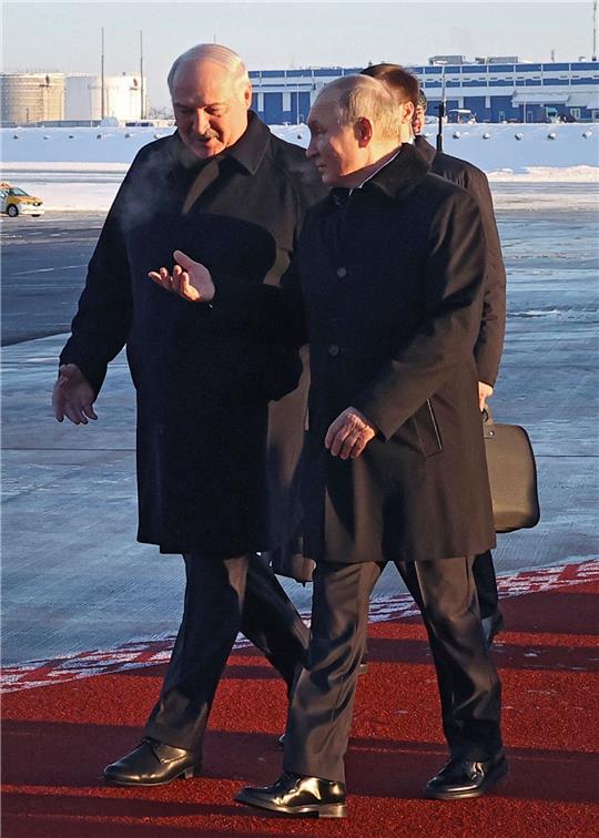 Wladimir Putin (r) wird bei seiner Ankunft auf dem Flughafen von Minsk von Alexander Lukaschenko empfangen.