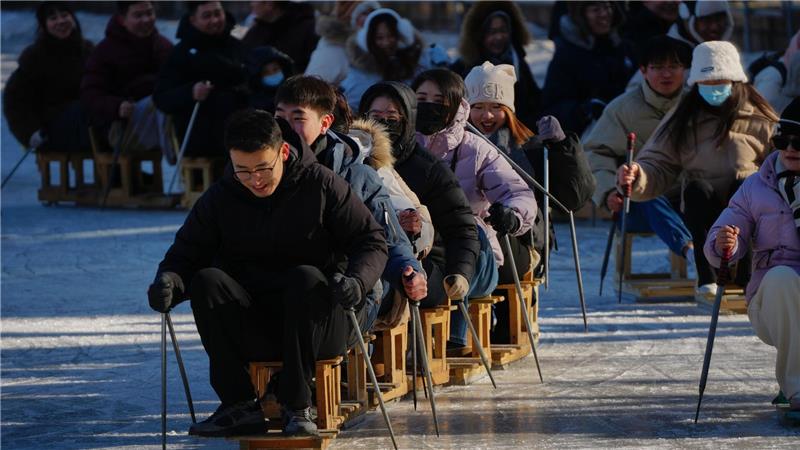 Wochenendspaß auf dem Eis: Stuhl-Skifahren im Park von Peking