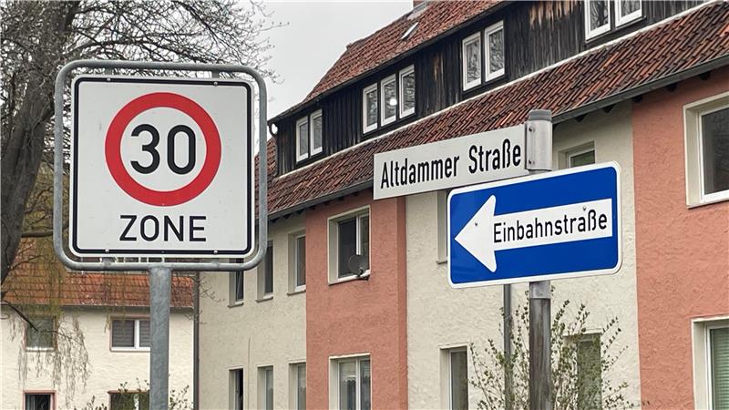 Verkehrsschilder an einer Straßenecke mit einem 30-Zone-Schild, einem Straßenschild "Altdammer Straße" und einem blauen Einbahnstraßenschild mit Pfeil nach links vor Wohnhäusern
