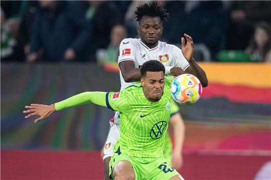 Wolfsburgs Felix Nmecha (v) spielt gegen Leverkusens Edmond Tapsoba.