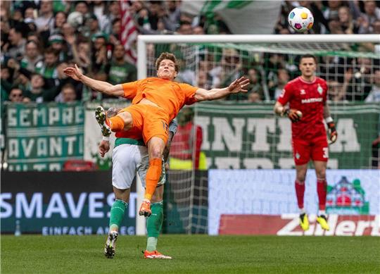 Wolfsburgs Kevin Behrens (vorne) und Bremens Marco Friedl kämpfen um den Ball.