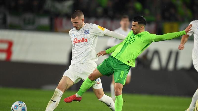 Wolfsburgs Mohamed Amoura (r) spielt gegen Kiels David Zec.