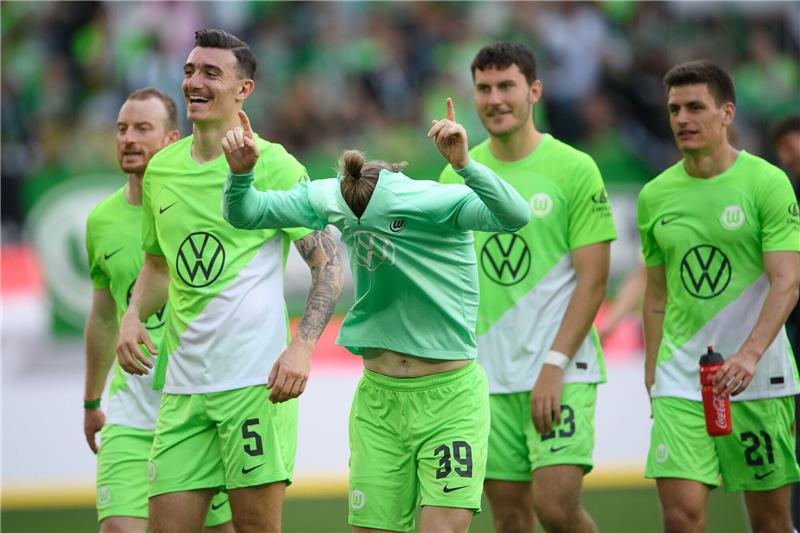 Dritter Sieg in Serie: Wolfsburg ist fast gerettet Wolfsburgs Patrick Wimmer (M) jubelt nach dem Schlusspfiff.