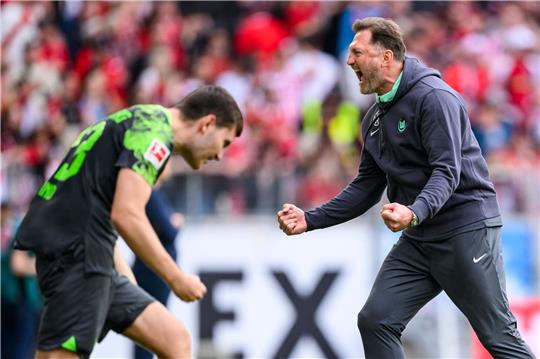 Wolfsburgs Trainer Ralph Hasenhüttl (r) jubelt nach dem Spiel mit Wolfsburgs Jonas Wind (l).
