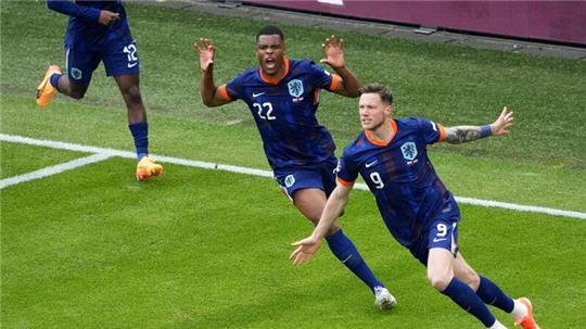 Wout Weghorst (M) von den Niederlanden jubelt nach seinem Tor zum 1:2 mit Denzel Dumfries (l).