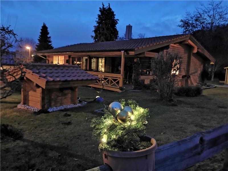Wunderbar leuchtet das Holzhaus in der abendlichen Dämmerung und bringt etwas Licht in die längsten Nächte des Jahres.