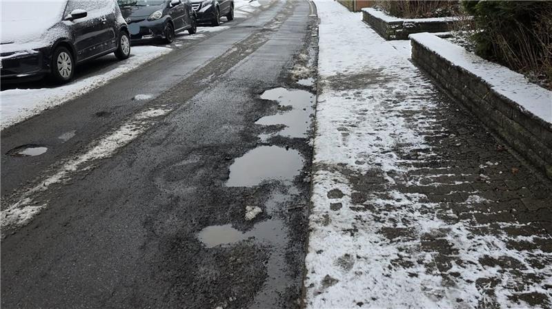GZ-Leser äußern Unmut über Goslarer Schlaglöcher Schneebedeckter Gehweg neben einer Straße mit mehreren Schlaglöchern und geparkten Autos.