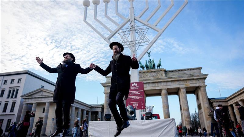 Yehuda Teichtal (l), orthodoxer Rabbiner, und Rabbi Shmuel Segal tanzen bei der Einweihung des Chanukka-Leuchters am Brandenburger Tor in Berlin.